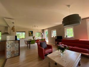 een woonkamer met een rode bank en een tafel bij Het Achterhoeks Voorrecht in Aalten