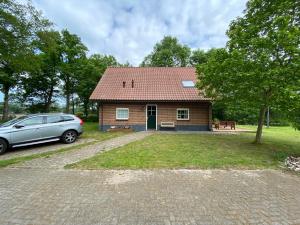 een klein huis met een auto ervoor geparkeerd bij Het Achterhoeks Voorrecht in Aalten