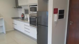 y cocina con nevera y microondas. en START Villa Morra Rent Apartments, en Asunción