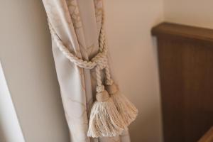 a curtain with a rope and tassels on it at Untermairhof B&B Christine in Lagundo