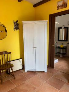 ein weißer Schrank in einem Zimmer mit gelber Wand in der Unterkunft IL Borgo 31 in Scapoli