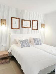Un dormitorio con una gran cama blanca con dos almohadas. en RENTALMARE, en Denia