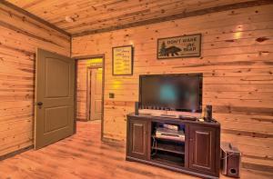 a living room with a flat screen tv in a cabin at Spacious Family Home with Fire Pit by Norfork Lake! in Mountain Home