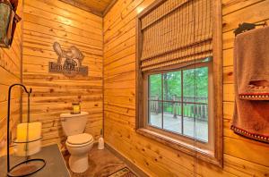 a log cabin bathroom with a toilet and a window at Spacious Family Home with Fire Pit by Norfork Lake! in Mountain Home +19 photos