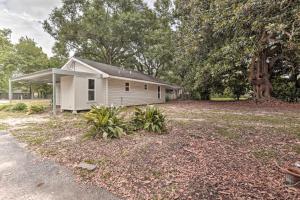 uma pequena casa branca com árvores ao fundo em Lake Charles Home 1 Mi to Public Boat Launch em Lake Charles