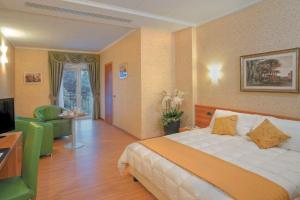 una camera d'albergo con letto e TV di Ele Green Park Hotel Pamphili a Roma