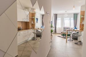Jacuzzi - Flexible SelfCheckIns 20 - Zagreb - Luxury - Garage - Smart - Brand New - Apartments Repinc في زغرب: مطبخ وغرفة معيشة مع طاولة وكراسي