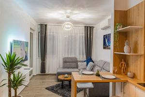sala de estar con mesa y sofá en Jacuzzi - Flexible SelfCheckIns 20 - Zagreb - Luxury - Garage - Smart - Brand New - Apartments Repinc en Zagreb