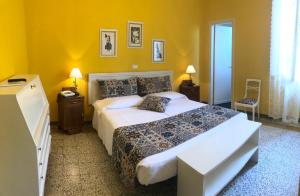 una camera con un grande letto e pareti gialle di Albergo Grande Italia a Marina di Pietrasanta