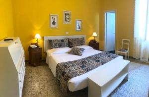 a bedroom with a large bed and yellow walls at Albergo Grande Italia in Marina di Pietrasanta