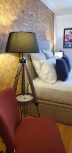 a bedroom with a bed with a lamp and a chair at Casa do Criativo ® Bed&Breakfast in Almada