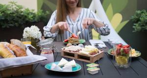 una mujer preparando comida en una mesa con platos de comida en The Leaf Boutique Hotel Lisbon, en Lisboa