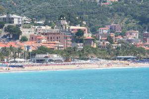 un grupo de personas en una playa cerca del agua en Grand Hotel Moroni, en Finale Ligure