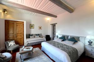 um quarto com 2 camas, um sofá e uma mesa em Bastide des Demoiselles em Roussillon