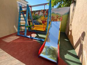 a playground with a slide on a red carpet at Lemoni Hotel in Anapa