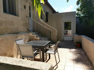 een patio met een tafel en stoelen en een trap bij manade Blanc - Gite la Fenière in Arles