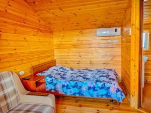 a bedroom with a bed in a log cabin at Хутірська 48 in Sanzhiyka