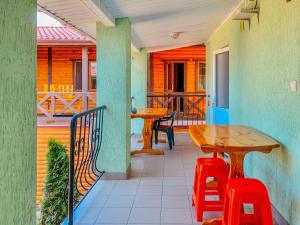 a porch with a wooden table and two stools at Хутірська 48 in Sanzhiyka
