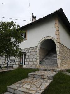 um edifício com um arco de pedra e escadas num quintal em Studio u selu Mačkat em Mačkat