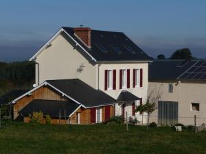 une maison blanche avec des panneaux solaires en haut dans l'établissement Chez Juliette Maison Gite Hôtel, à Rontignon
