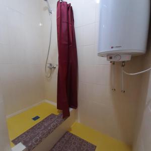 um chuveiro na casa de banho com uma cortina de chuveiro vermelha em ХОСТЕЛ : ул. Белопольское шоссе 21 em Sumy
