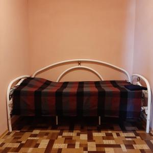 uma cama com um cobertor xadrez num quarto em ХОСТЕЛ : ул. Белопольское шоссе 21 em Sumy