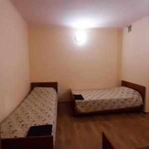um quarto com duas camas e uma luz na parede em ХОСТЕЛ : ул. Белопольское шоссе 21 em Sumy