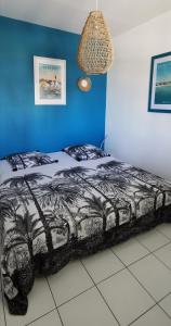 a bedroom with a bed with a black and white comforter at Savannah Guadeloupe in Saint-François