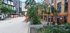 an empty city street with trees and buildings at Pentagos Centrum in Poznań