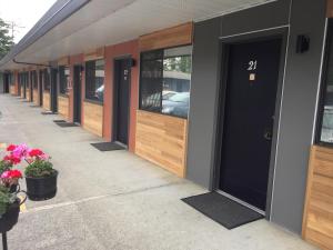 a row of doors on a building with flowers on the sidewalk at VIP Motel in Parksville