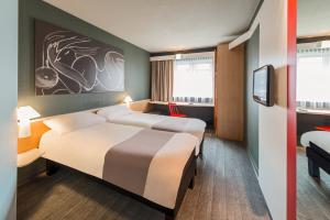 um quarto de hotel com duas camas e uma televisão em ibis Hotel Berlin Spandau em Berlim