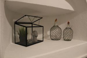 a shelf with two vases and a box on it at Cycladic Villa in Amorgos Island (Maison Shiro) in Arkesíni
