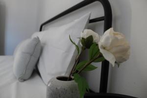 a vase with a white flower sitting on a bed at Cycladic Villa in Amorgos Island (Maison Shiro) in Arkesíni