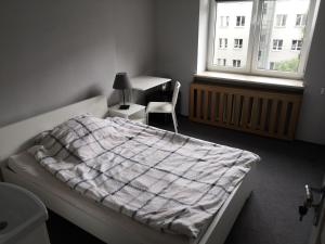 Schlafzimmer mit einem Bett, einem Schreibtisch und einem Fenster in der Unterkunft SHIRE Gdynia in Gdynia