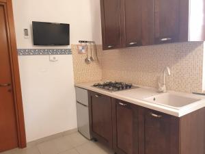eine Küche mit Spüle und einem weißen Kühlschrank in der Unterkunft Bilocale Blu - A casa di Ludovica e Martina in Gallipoli
