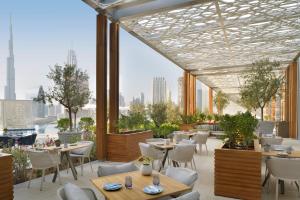 a dining room with tables and chairs and a balcony at Address Fountain Views in Dubai