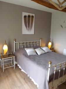 a bedroom with a large bed with two lamps at Maison à la Campagne in Blis-et-Born