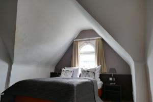 a bedroom with a bed and a window at DAS Steeps Ihr Brauhaus und Hotel in Cologne