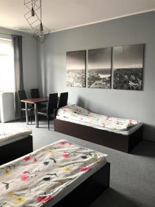 Pokój z 2 łóżkami i stołem z krzesłami w obiekcie SHIRE Gdynia w mieście Gdynia