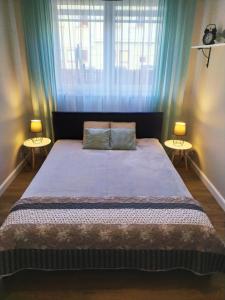 ギジツコにあるApartament Rodzinnyのベッドルーム1室(大型ベッド1台、テーブル2台付)