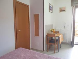 ein Schlafzimmer mit einem Tisch und einem Stuhl in der Unterkunft Monolocale Viola - A casa di Ludovica e Martina in Gallipoli