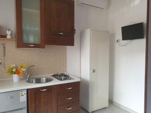 eine Küche mit einem weißen Kühlschrank und einer Spüle in der Unterkunft Monolocale Viola - A casa di Ludovica e Martina in Gallipoli