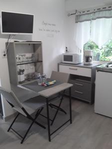 a small kitchen with a table and a microwave at Gîte les Oliviers les HERBIERS in Les Herbiers