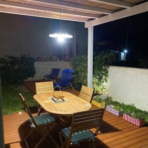 einen Holztisch und Stühle auf einer Terrasse in der Nacht in der Unterkunft Lele's Home in Favignana