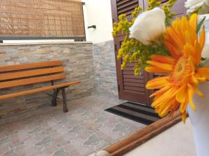 Eine Bank und eine Blumenvase neben einer Tür in der Unterkunft Monolocale Viola - A casa di Ludovica e Martina in Gallipoli