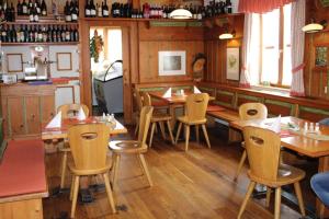 uma sala de jantar com mesas e cadeiras de madeira num restaurante em Gasthof Diewald em Raach am Hochgebirge