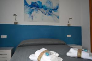 una camera da letto con un letto e asciugamani di Alojamiento CAZORLA DELUXE a Cazorla