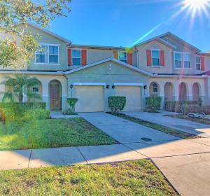 a large house with a garage in a yard at 4 Bedroom SunHaven Townhouse with Pool Near Disney in Kissimmee