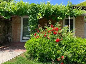 un jardín con flores rojas frente a una casa en Relais Del Lago, en Capannori
