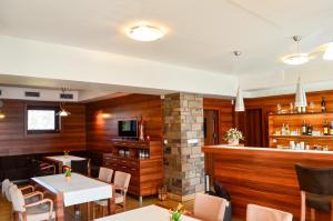 a restaurant with wooden walls and tables and a fireplace at Wellness Villa Liptov in Žiar +71 photos